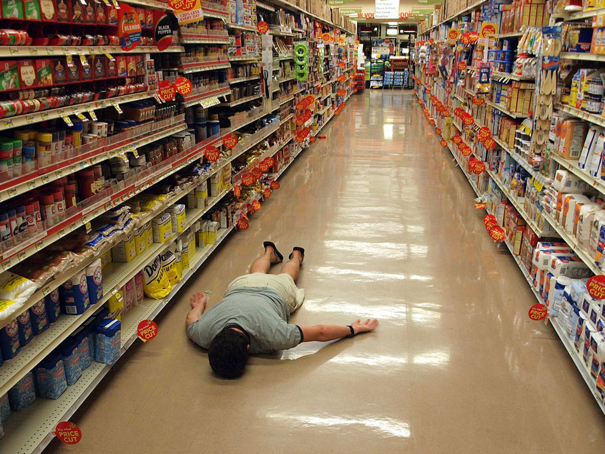 Man planking in supermarket