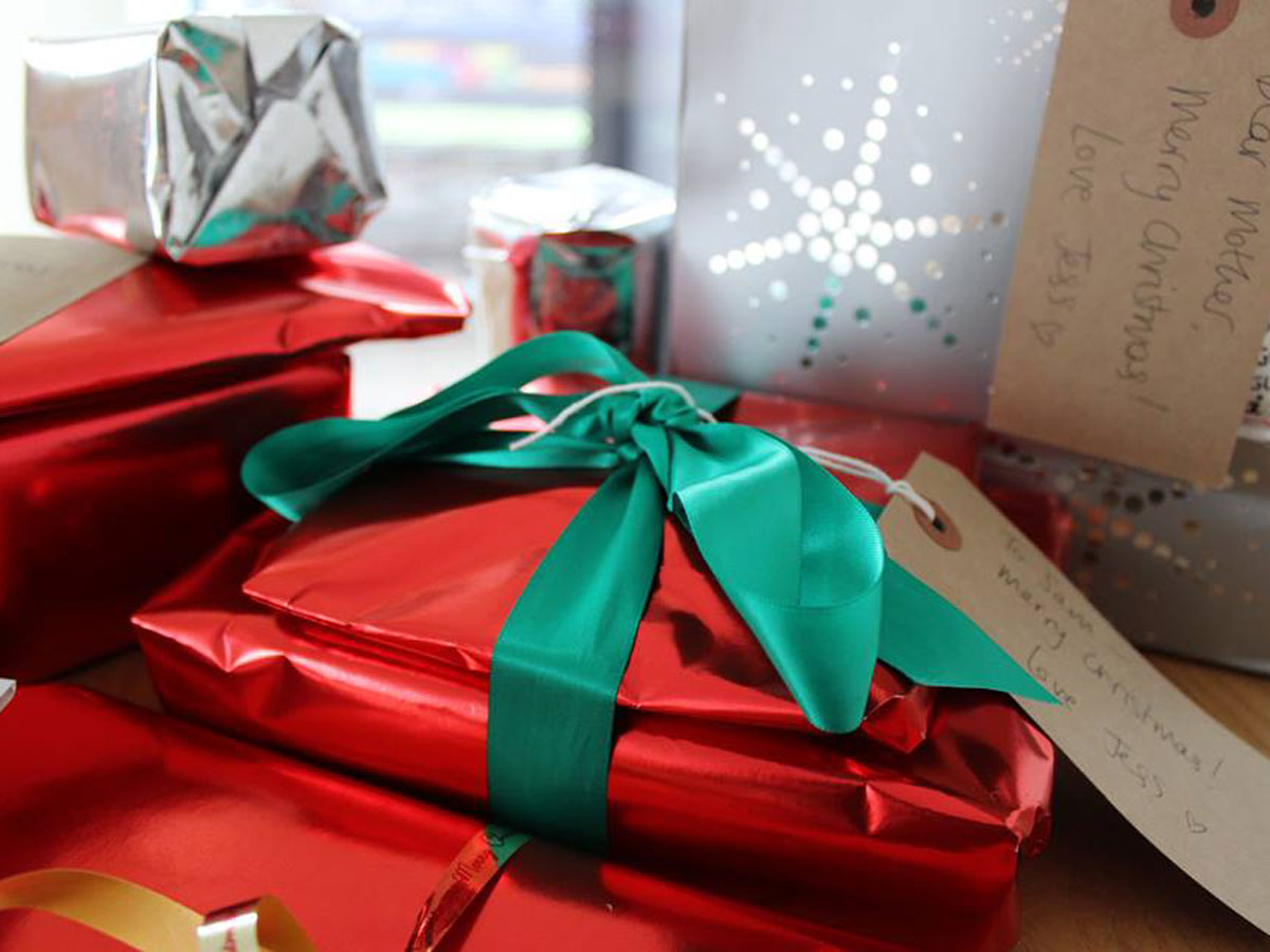 Christmas presents all wrapped up in red paper with ribbons