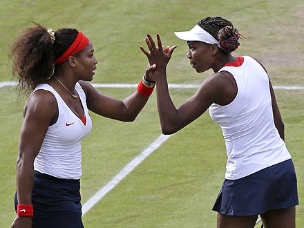 Venus & Serena Williams high-five on a tennis court