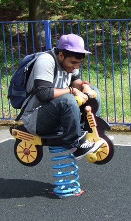 Sham on a play motorbike in a park