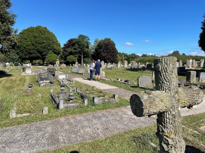 A couple of people walking in a cemetery